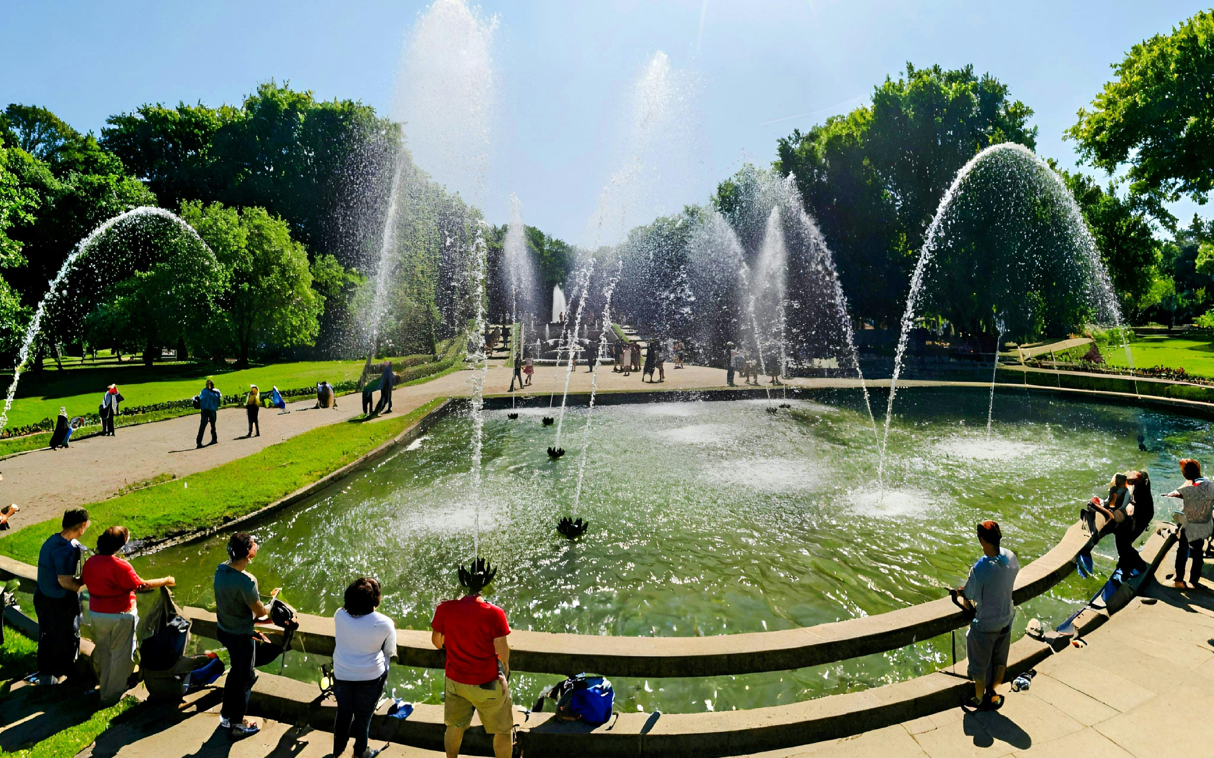 Fountains at Versailles Gardens with tourists on a guided golf cart and bike tour.