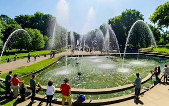 Fountains at Versailles Gardens with tourists on a guided golf cart and bike tour.