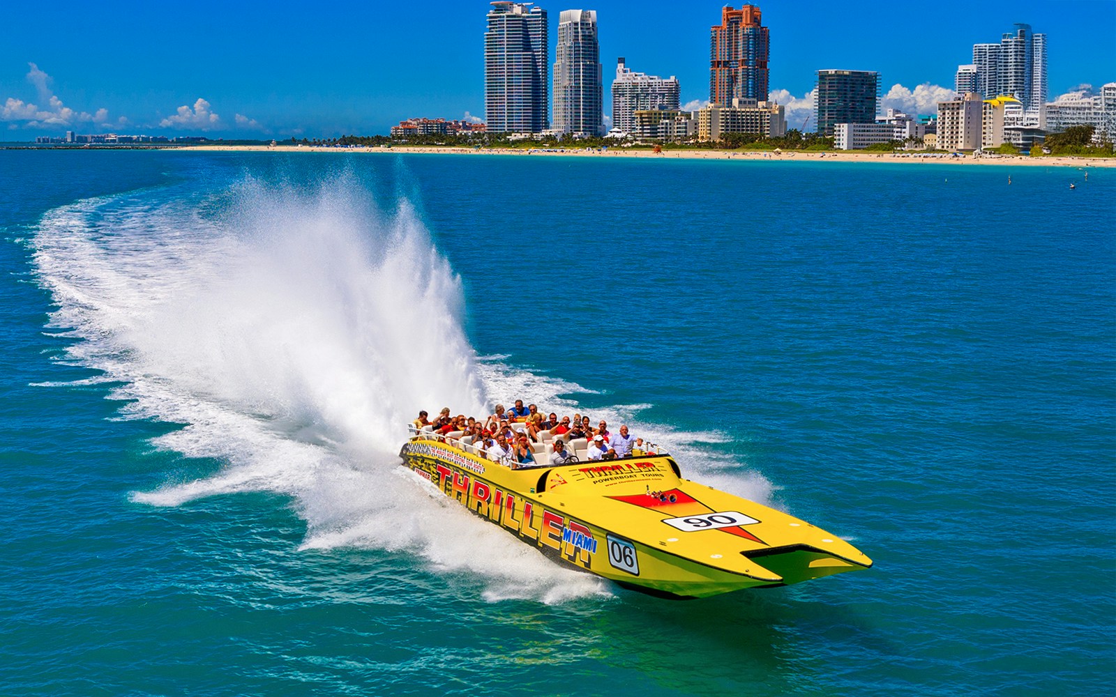 Speedboat cruising past Miami skyline on sightseeing tour.