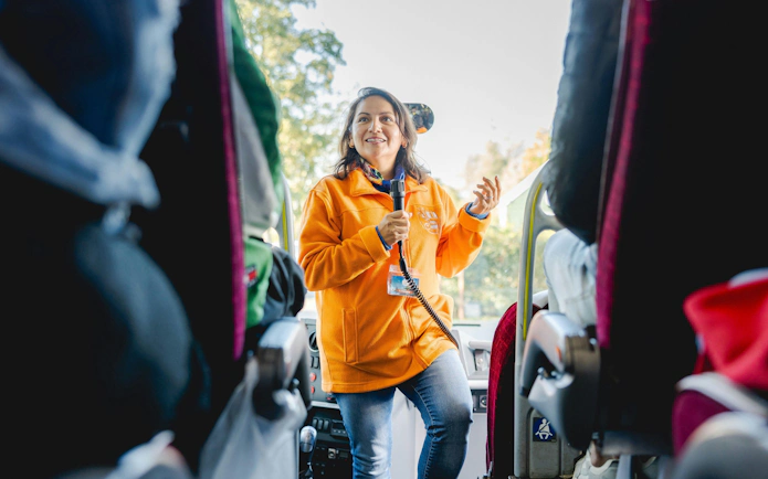 Tour guide speaking to passengers on a bus tour.