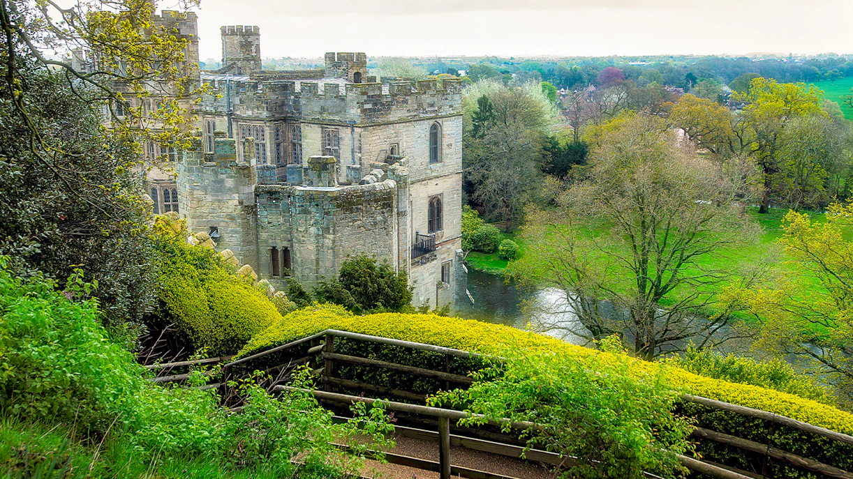 Warwick Castle view from the Mound with surrounding greenery and moat.