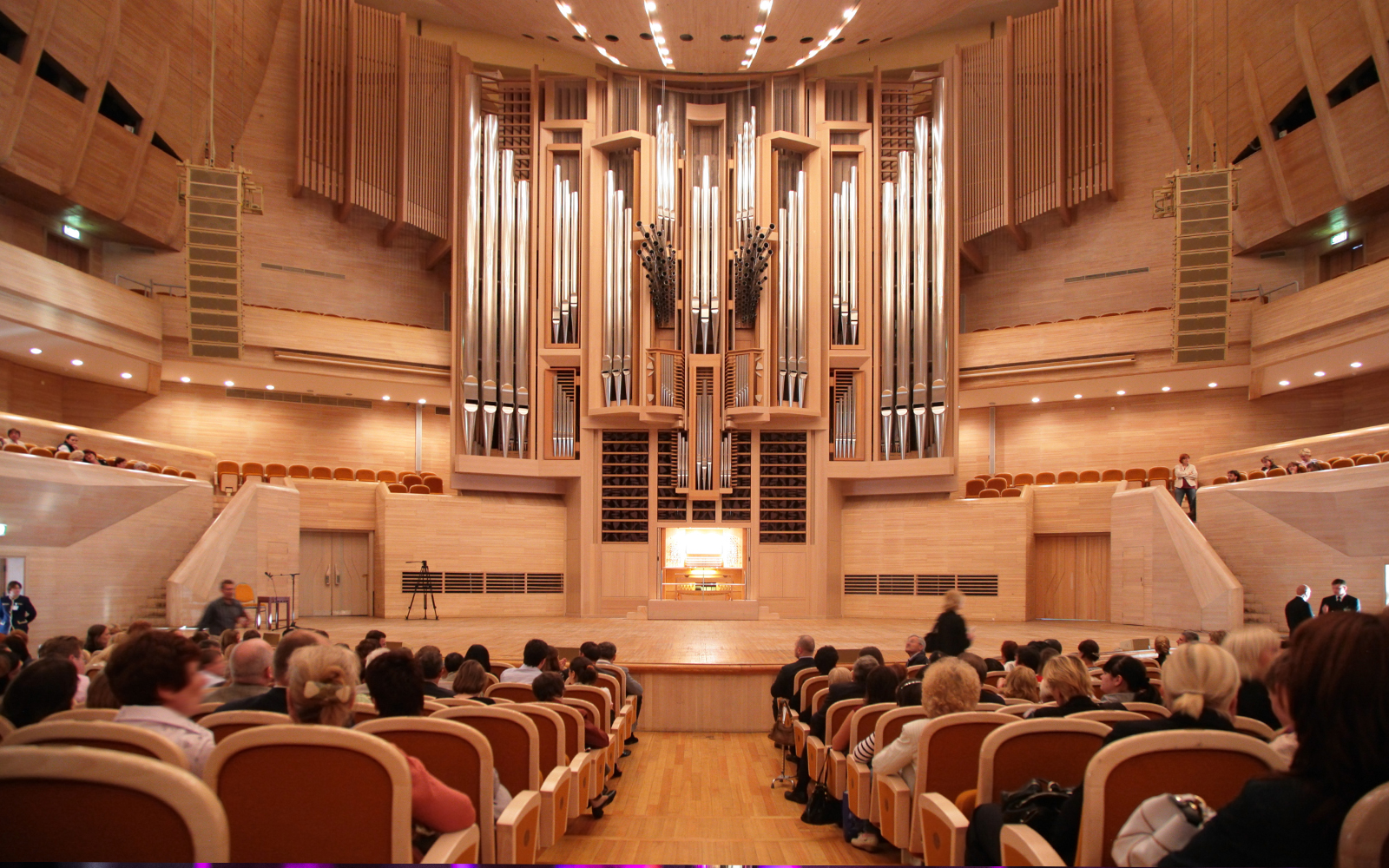 Concert hall interior with audience seated, large pipe organ at front, Vienna concert tour.