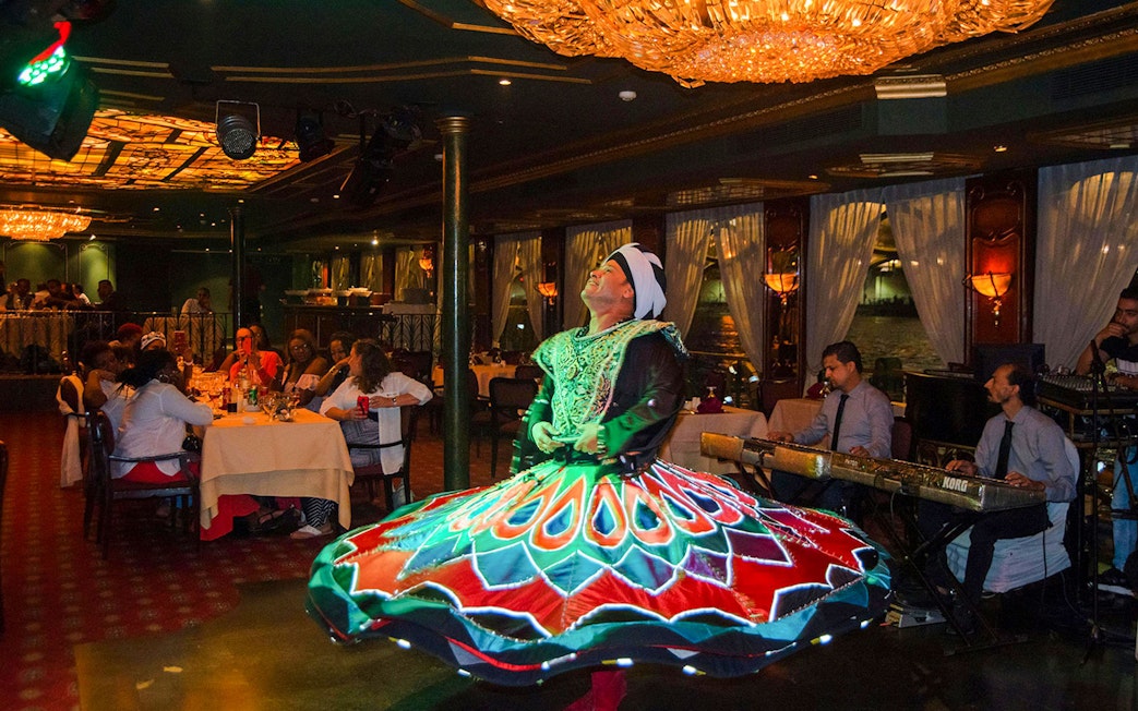 Dancer performing on a luxury Nile dinner cruise with live music.