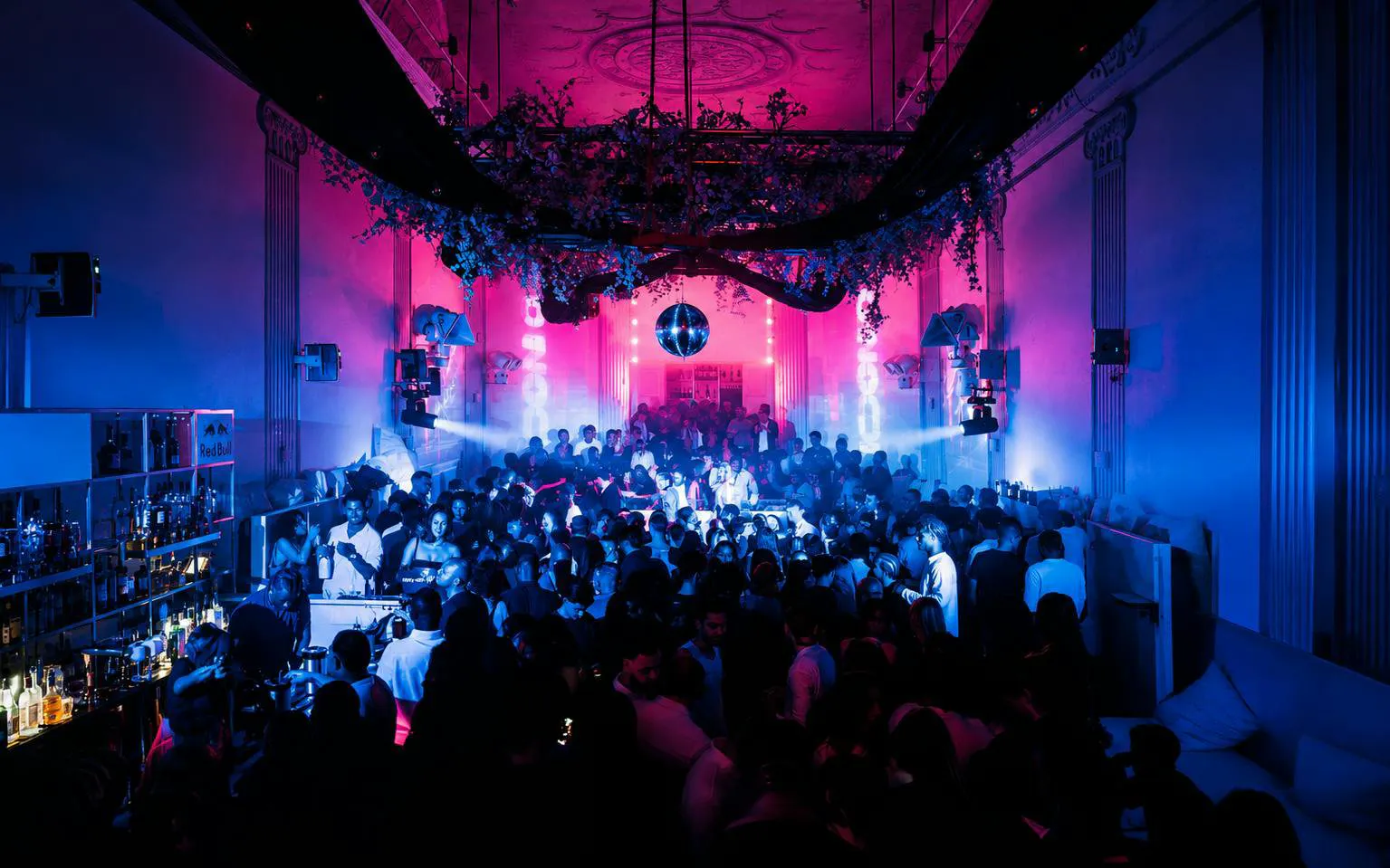 Crowded nightclub with vibrant lighting and a disco ball at SUPPERCLUB Amsterdam.