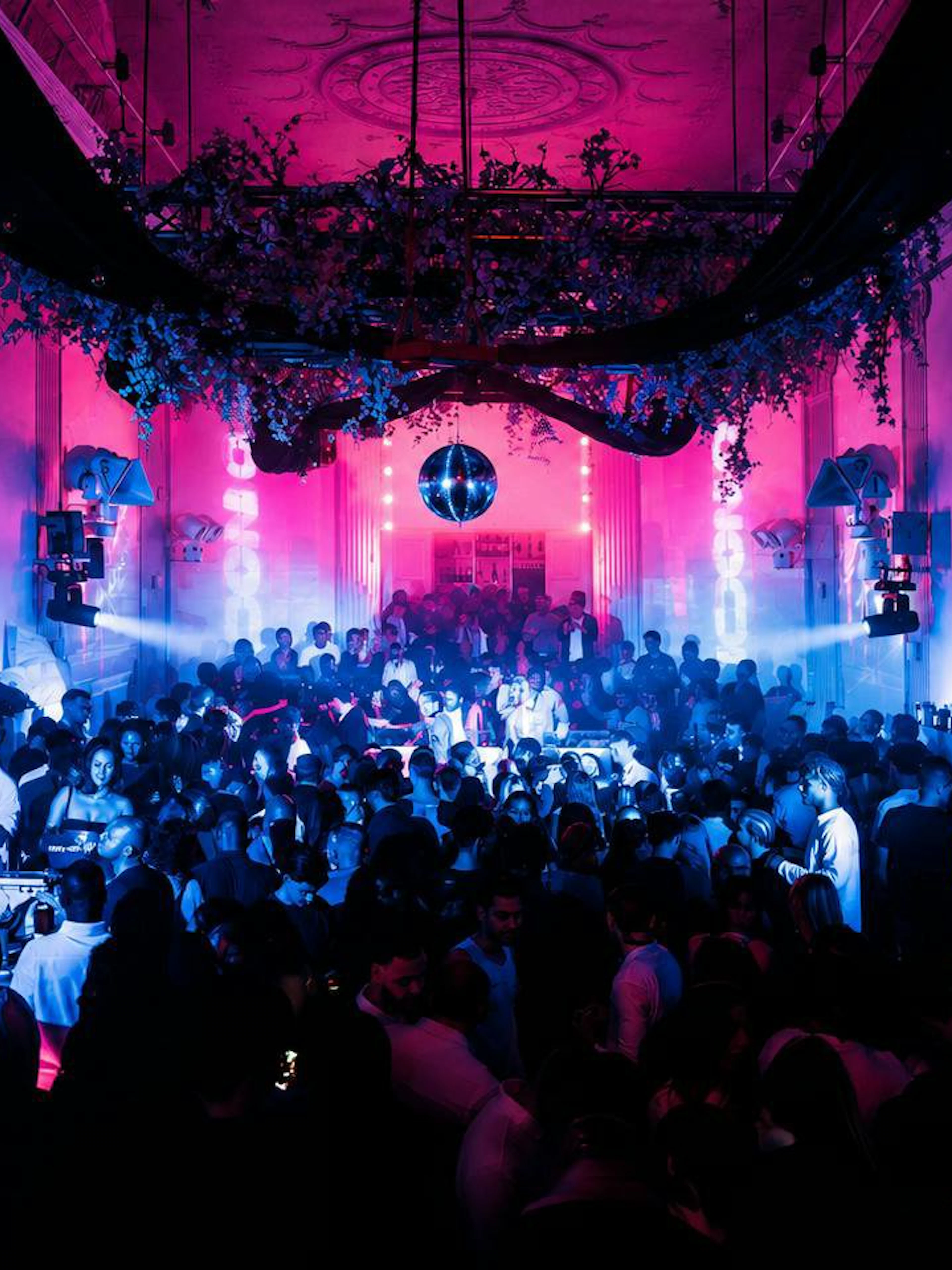 Crowded nightclub with vibrant lighting and a disco ball at SUPPERCLUB Amsterdam.