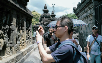 Tourists photographing stone carvings at Borobudur Temple, Indonesia.