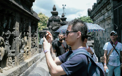 Tourists photographing stone carvings at Borobudur Temple, Indonesia.