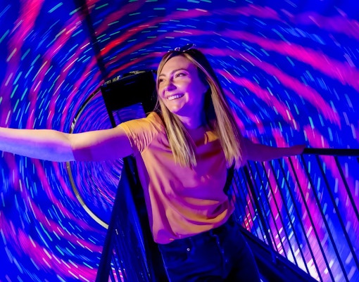 Visitors exploring vortex tunnel exhibit at the Museum of Illusions, Madrid.
