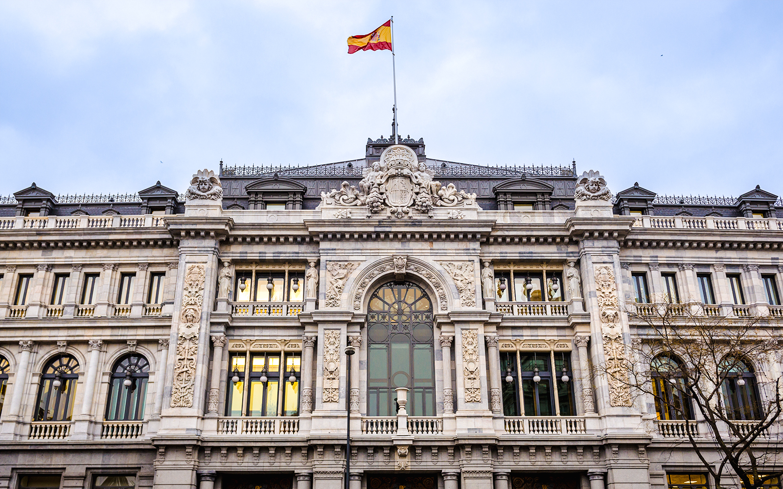 Bank of Spain building facade with Spanish flag in Madrid.