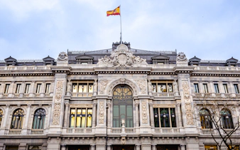 Bank of Spain building facade with Spanish flag in Madrid.