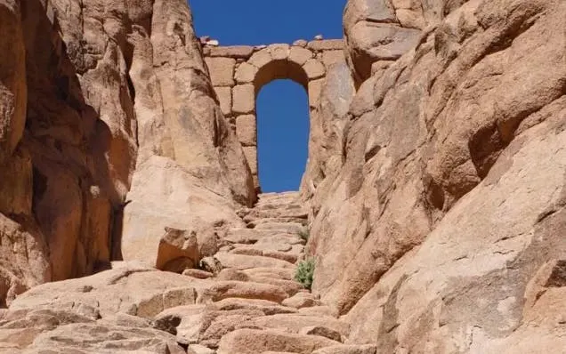 Stone steps leading to an archway on Mount Sinai, Egypt, under a clear blue sky.