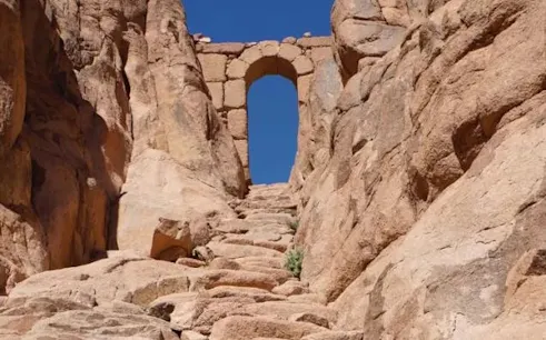 Stone steps leading to an archway on Mount Sinai, Egypt, under a clear blue sky.