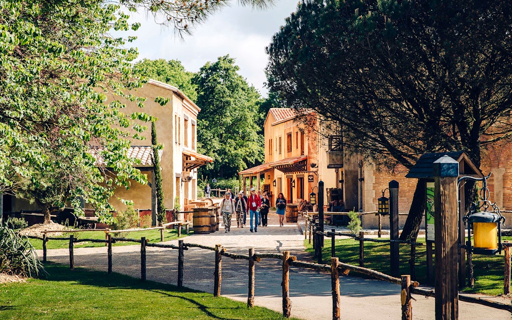 Visitors walking through a historic village at Puy du Fou, France.