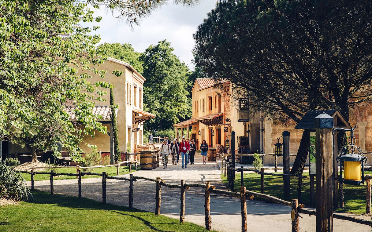 Visitors walking through a historic village at Puy du Fou, France.