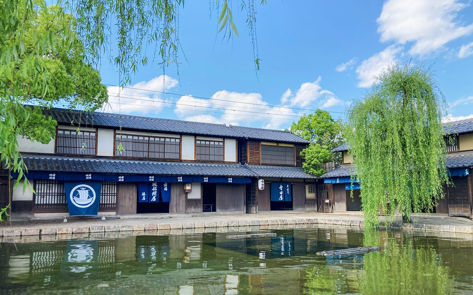 Traditional Japanese buildings by a pond at Toei Kyoto Studio Park.