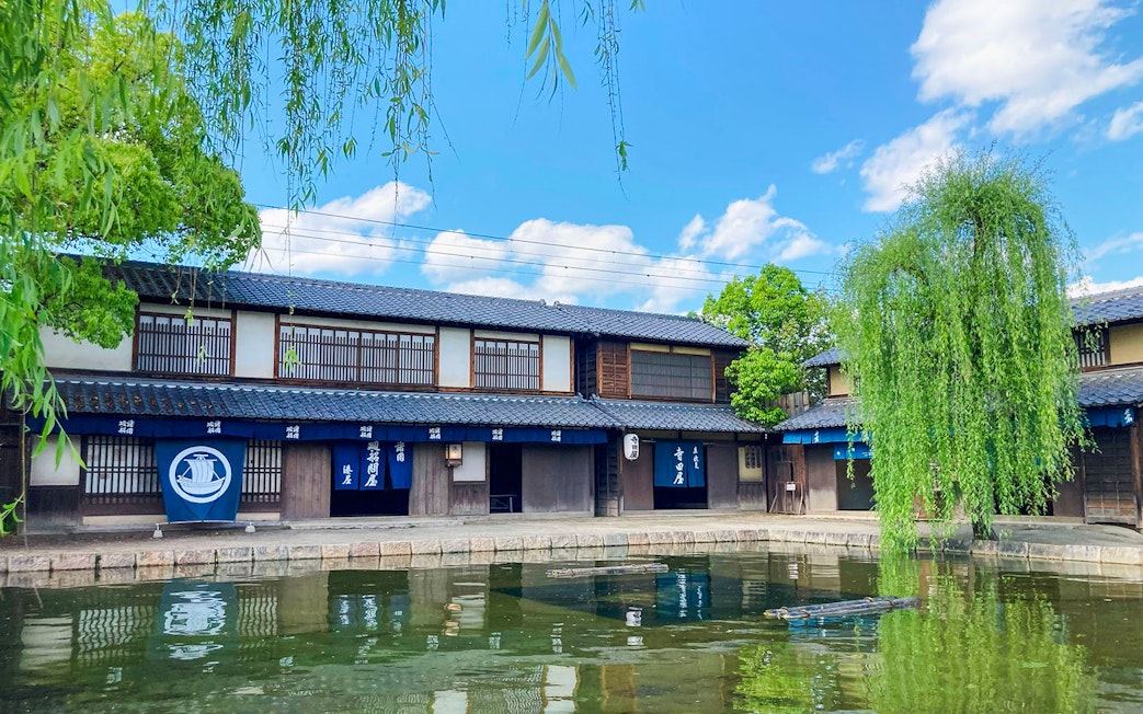 Traditional Japanese buildings by a pond at Toei Kyoto Studio Park.