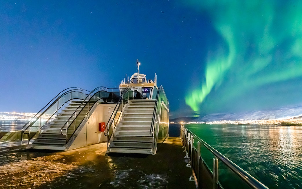 Cruise deck view with Northern Lights over the ocean.