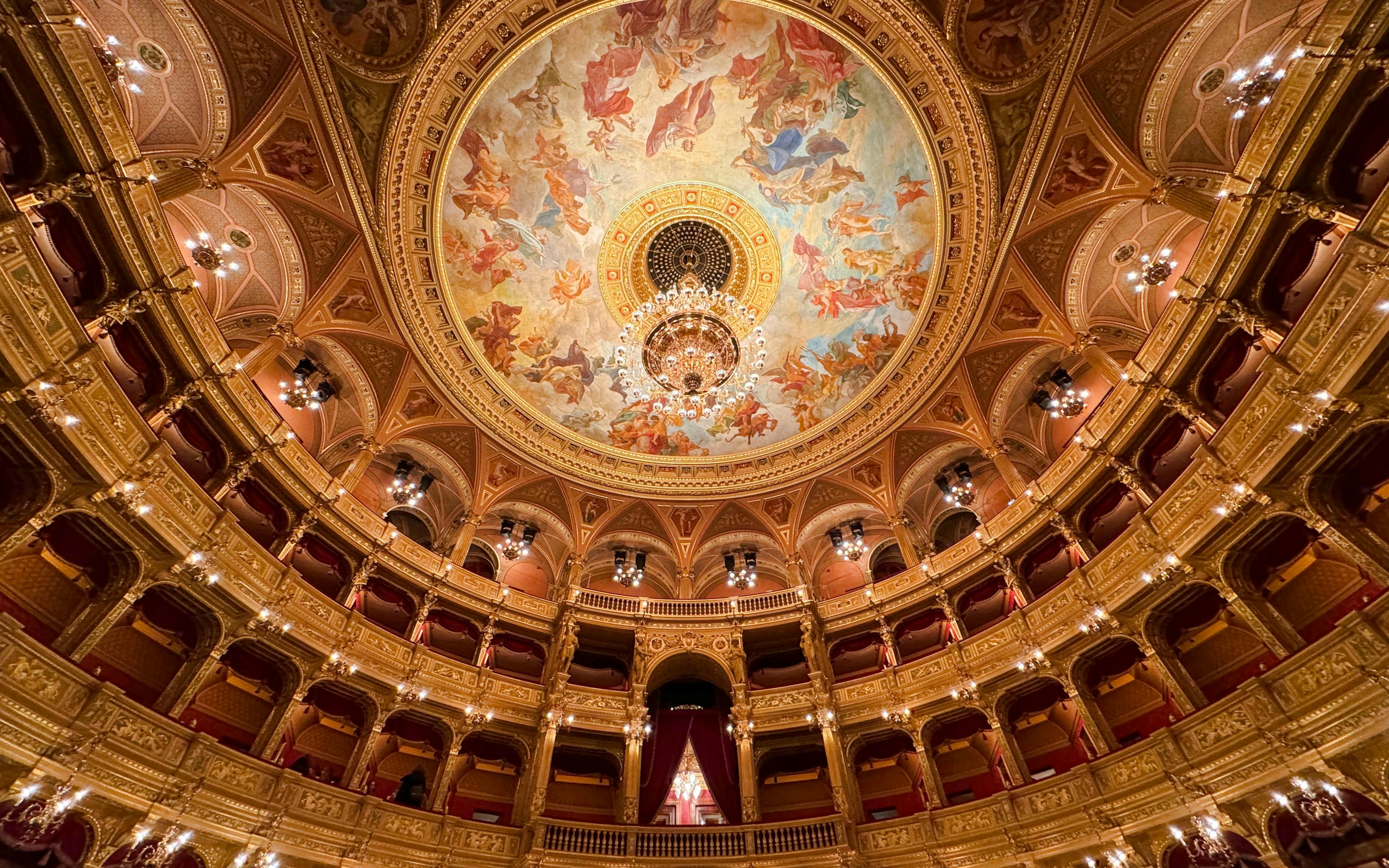 Hungarian State Opera House interior with ornate ceiling fresco and chandelier.