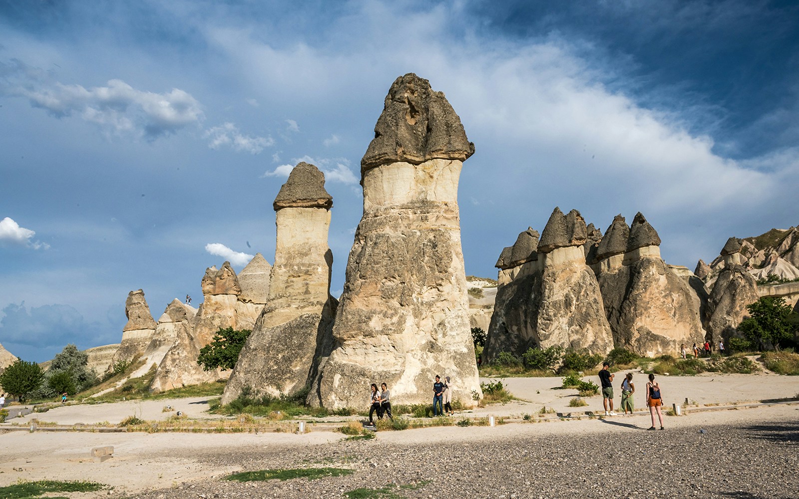 Fairy chimneys in Pasabag, Cappadocia with tourists exploring the unique rock formations.