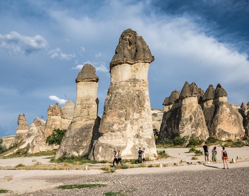 Fairy chimneys in Pasabag, Cappadocia with tourists exploring the unique rock formations.
