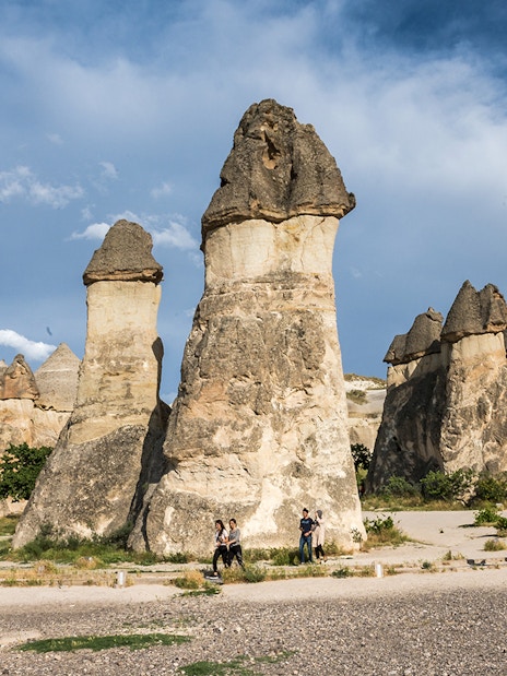 Fairy chimneys in Pasabag, Cappadocia with tourists exploring the unique rock formations.