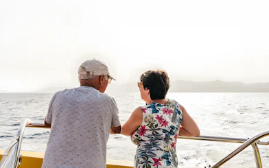 Tourists enjoying sunset views on a speedboat during a dolphin cruise.