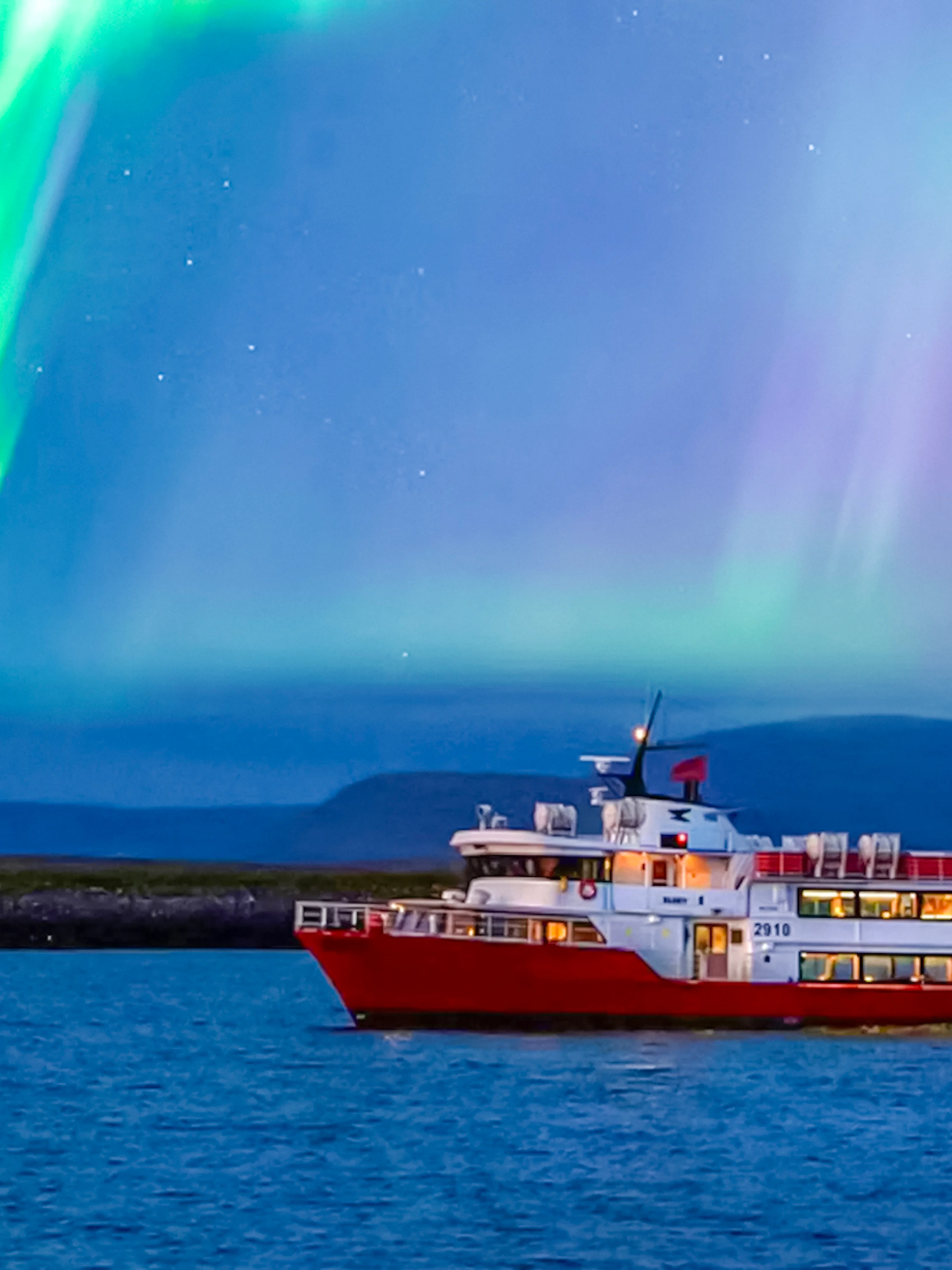 Cruise ship under northern lights in Iceland.