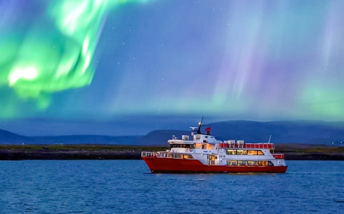 Cruise ship under northern lights in Iceland.