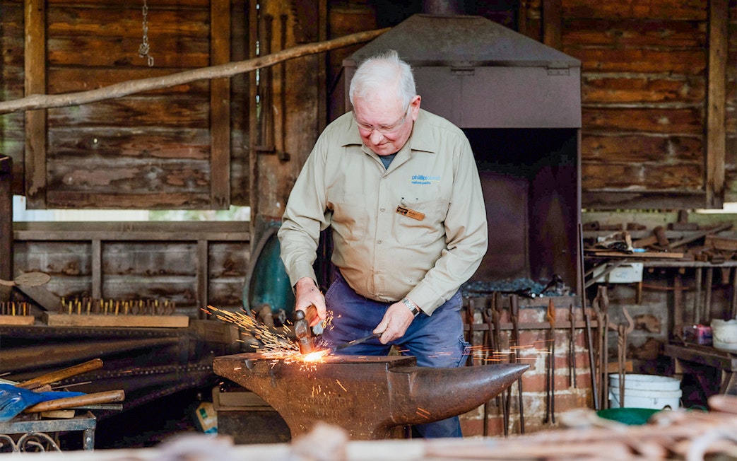 Blacksmith working at an anvil in Churchill Island, Phillip Island Nature Parks.