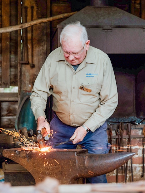 Blacksmith working at an anvil in Churchill Island, Phillip Island Nature Parks.