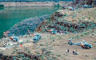 Helicopters landed at Grand Canyon West with tourists enjoying a champagne picnic by the canyon.
