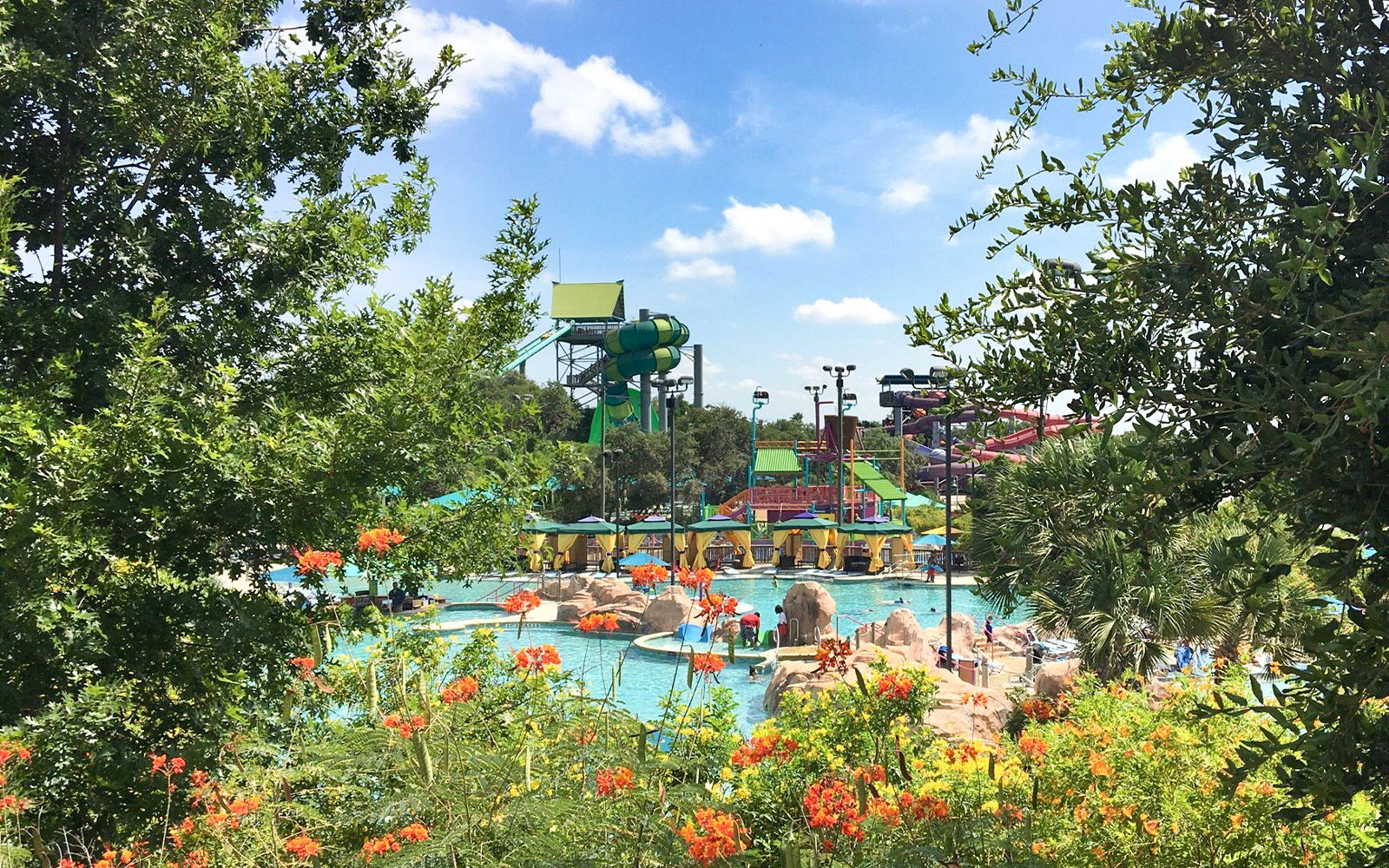 Water slides and pools at Aquatica San Antonio, Texas, surrounded by lush greenery.