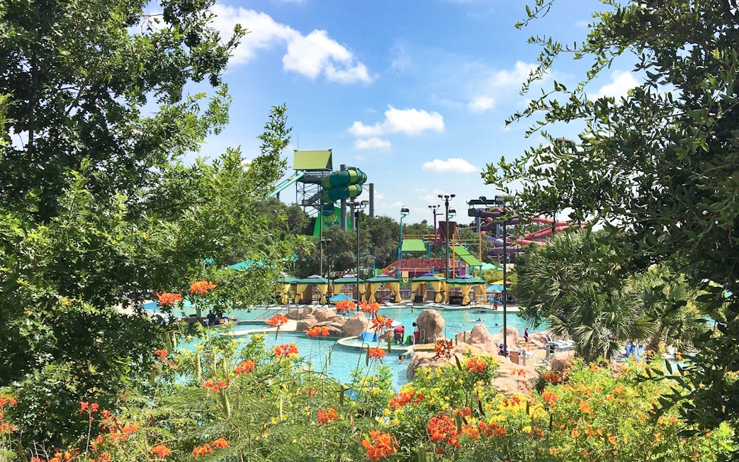 Water slides and pools at Aquatica San Antonio, Texas, surrounded by lush greenery.