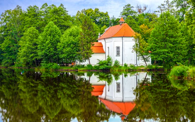 Church on the water surrounded by trees in Zwierzyniec, Poland.