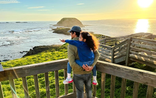 Father and daughter enjoying sunset view at Nobbies boardwalk, Phillip Island.