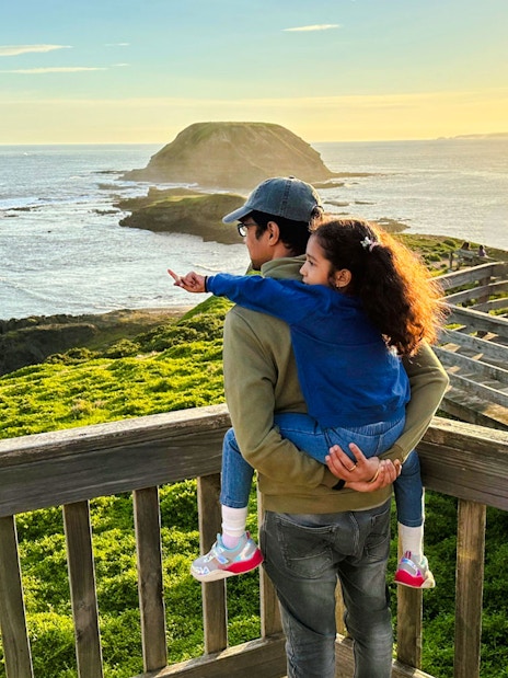 Father and daughter enjoying sunset view at Nobbies boardwalk, Phillip Island.
