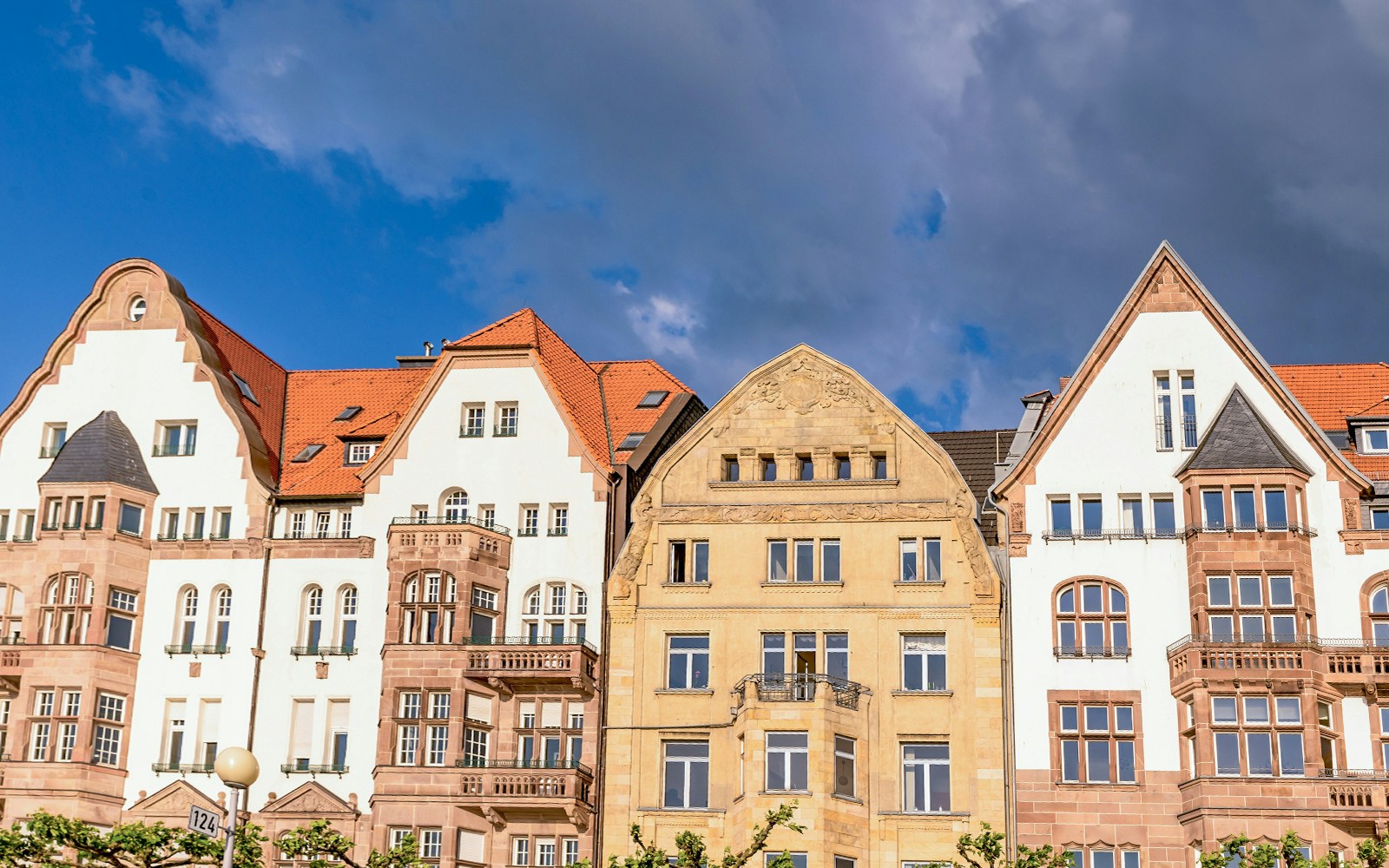 Historic buildings with red roofs in Düsseldorf under a cloudy sky.