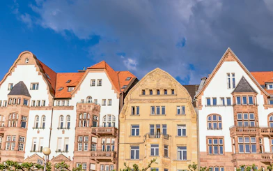 Historic buildings with red roofs in Düsseldorf under a cloudy sky.
