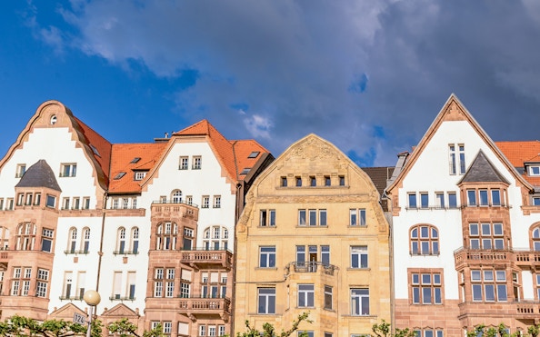 Historic buildings with red roofs in Düsseldorf under a cloudy sky.