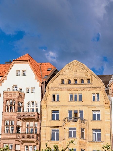 Historic buildings with red roofs in Düsseldorf under a cloudy sky.