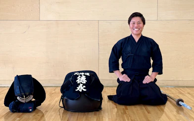 Samurai instructor in traditional attire with gear in Sapporo dojo.