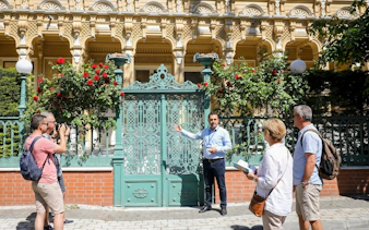 Tour guide with guests at ornate gate on Princes' Islands tour.