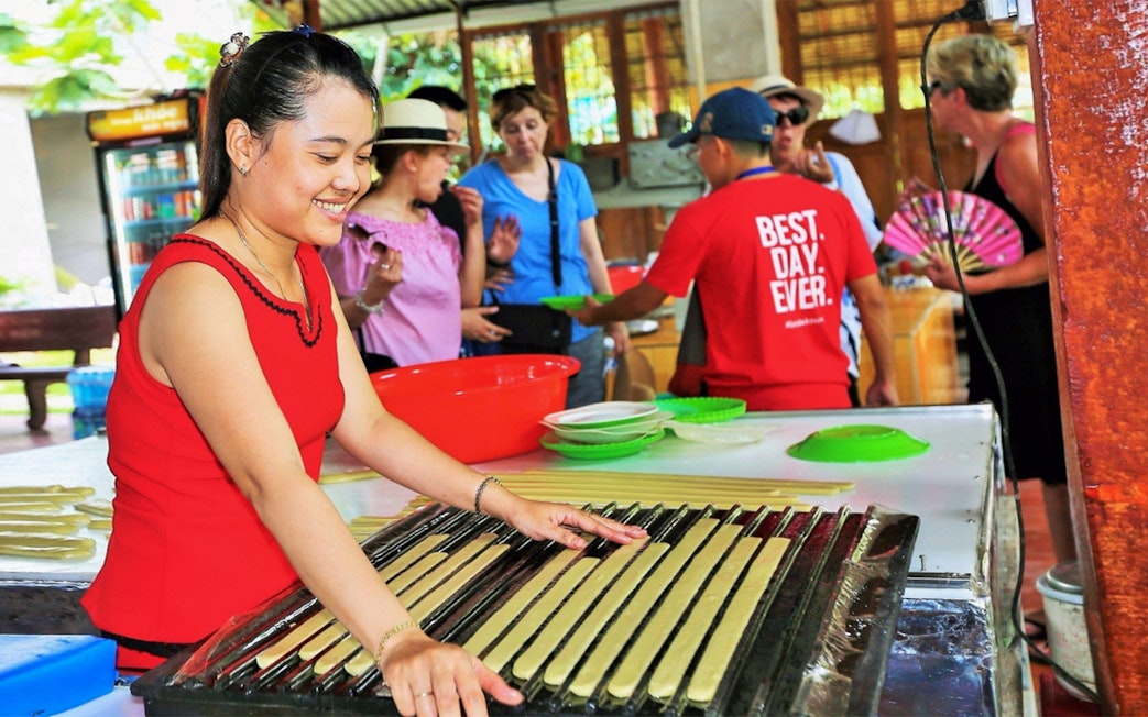 Woman demonstrating traditional candy making on Mekong Delta Full Day Tour.