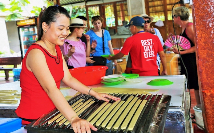 Woman demonstrating traditional candy making on Mekong Delta Full Day Tour.