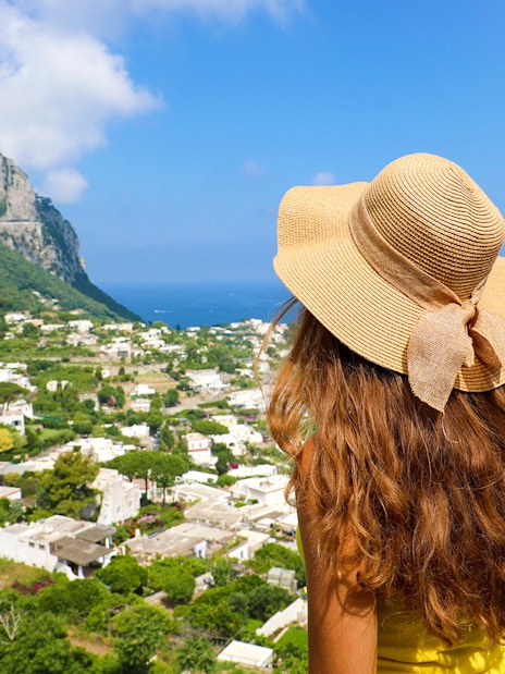 Woman overlooking Capri Island landscape with sea view, Italy.
