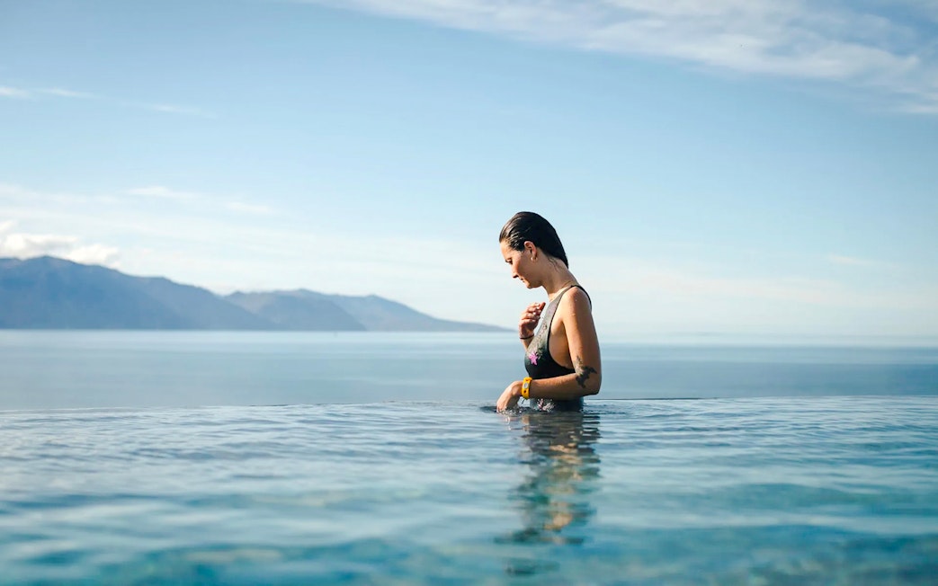 Guest enjoying Geosea Geothermal baths with ocean view in Iceland.