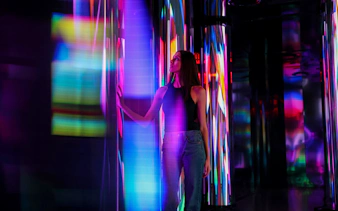 Person exploring colorful light installation at Edge Observatory, New York.
