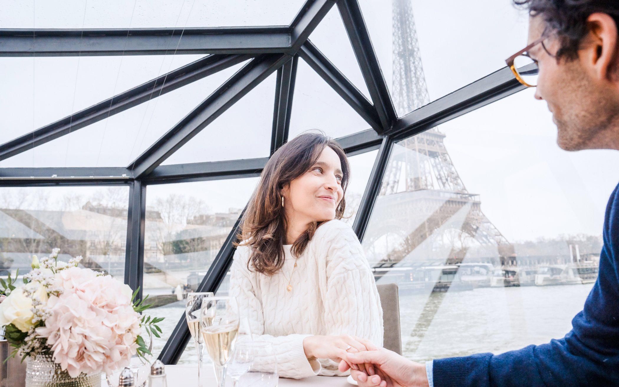 Couple enjoying Bateaux Mouches Seine River cruise with Eiffel Tower view.