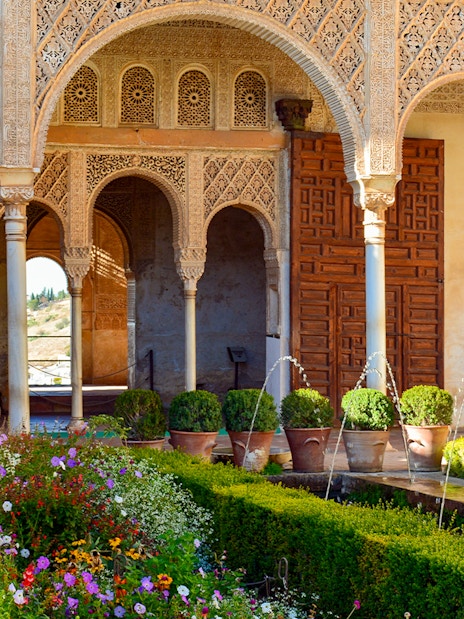 Palace of the Patio de la Acequia del Generalife, Alhambra with arches and garden.