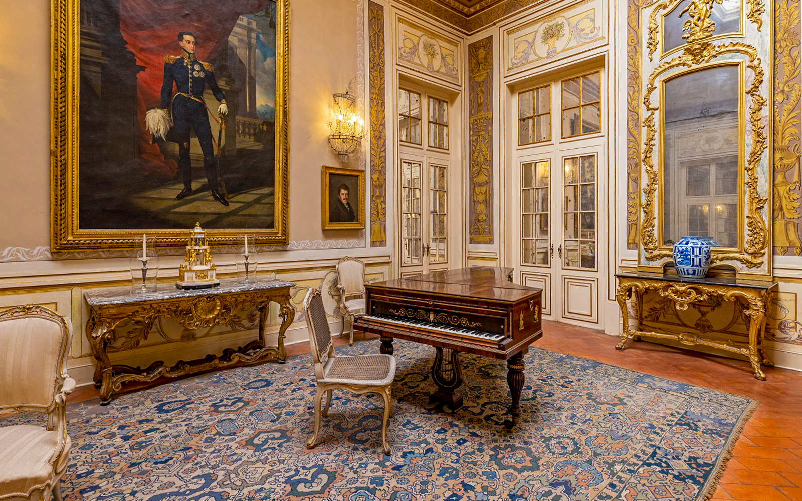 National Palace of Queluz Lantern Room with ornate furniture and large portrait.